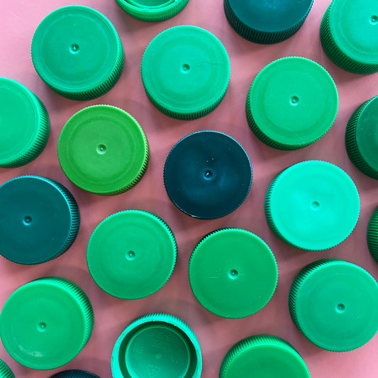 Granulated green plastic bottle caps