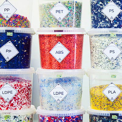 Precious Plastic | Shredded tubs of labelled plastics