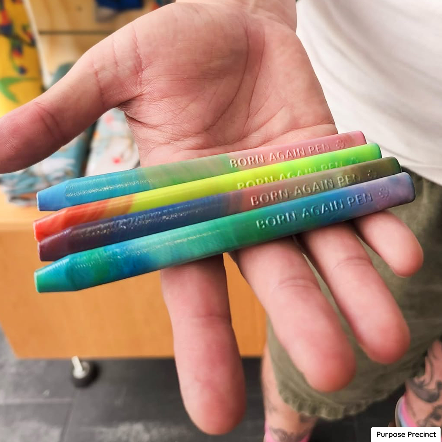 Rainbow recycled plastic pens made using Precious Plastic recycling methods