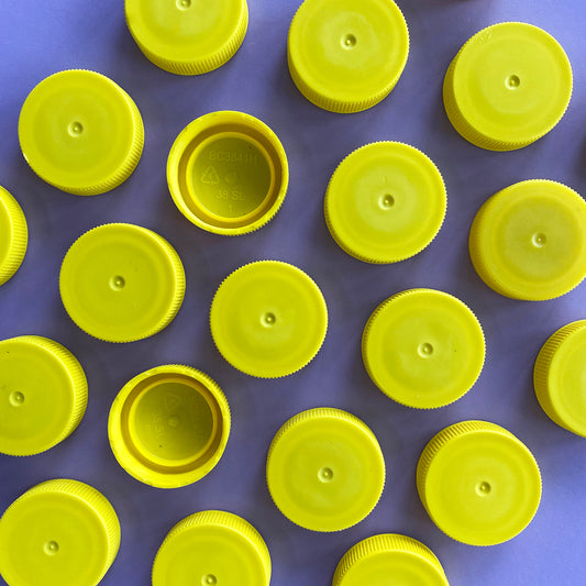 Yellow plastic bottle lids shredded for recycling